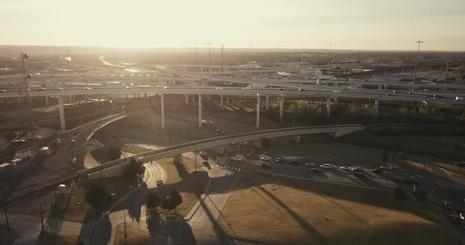 Cars driving down many highways on a sunny day