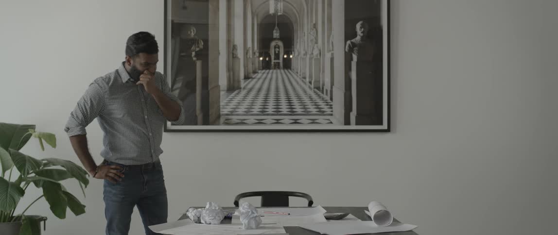 A man paces near a paper