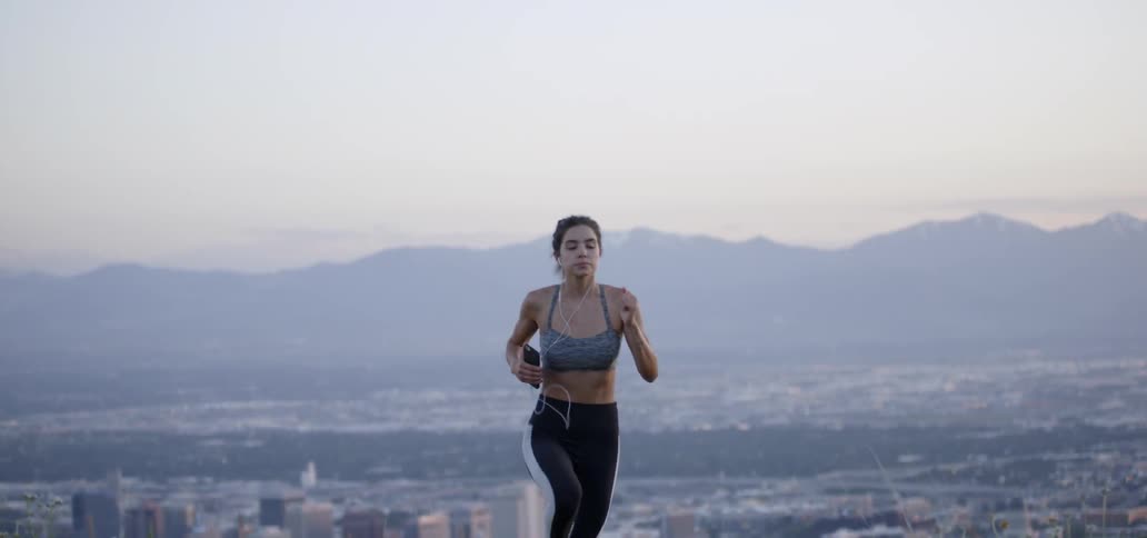 Woman jogging away from a city