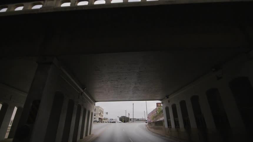 The tunnel is dark leading out into the cloudy sky