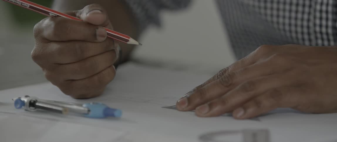 Person draws a line with a pencil against a ruler