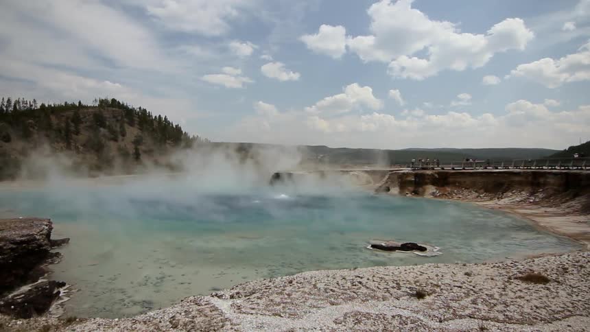Steam rises from a shallow pool of water