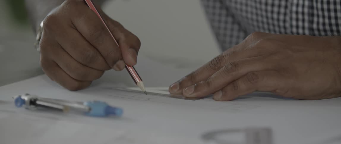 Person draws a line against a ruler with a pencil