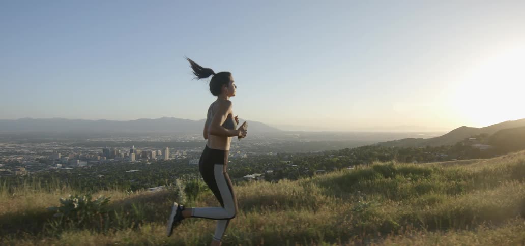 A woman is running on a hilltop