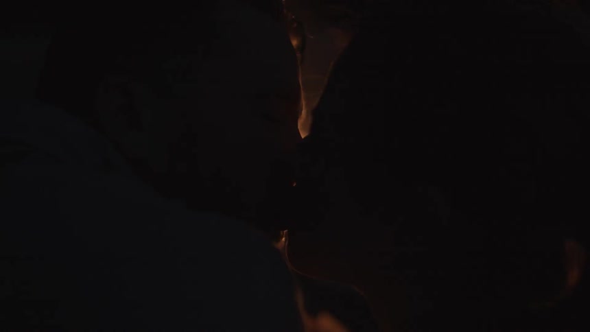 Man and woman kissing in the firelight