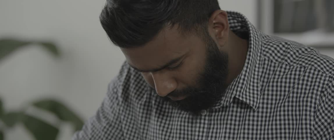 Man sitting looks down at his work