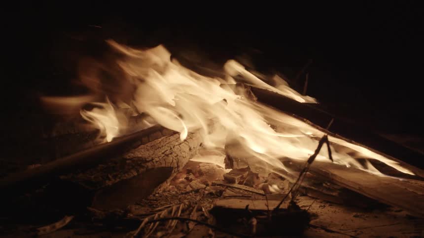 A camp fire burns at night
