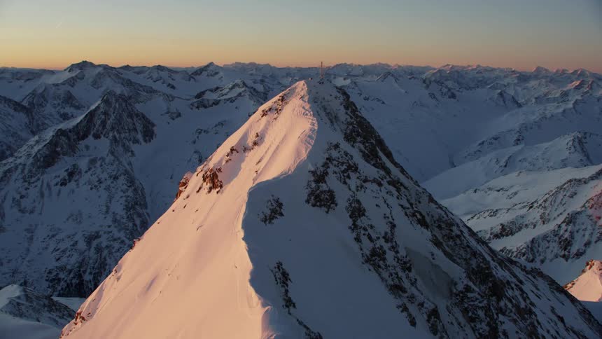 A snowy mountain at sunset