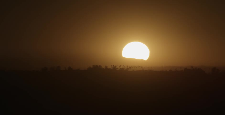 Sun setting over flat landscape