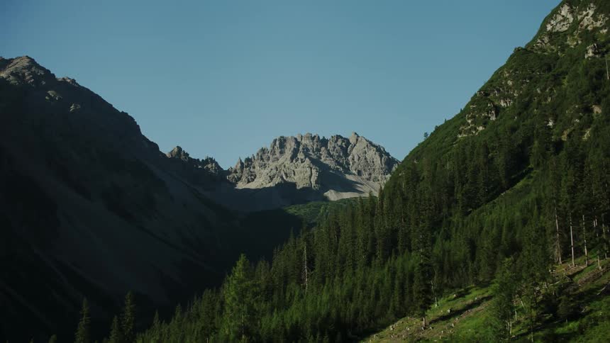The mountain is steep with many trees on the side