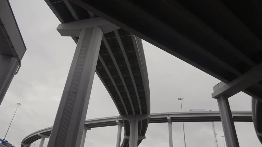 Gray clouds hang over a freeway complex during the day