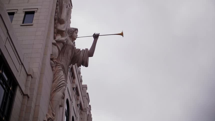 View of a statue on the side of a cloudy building