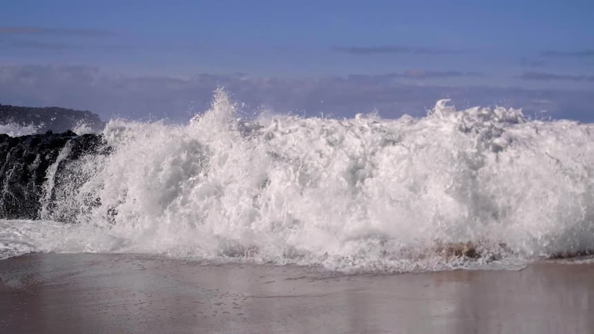 The waves crash against the beach