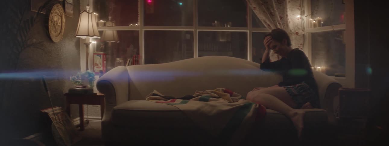 Woman sits on a couch laughing