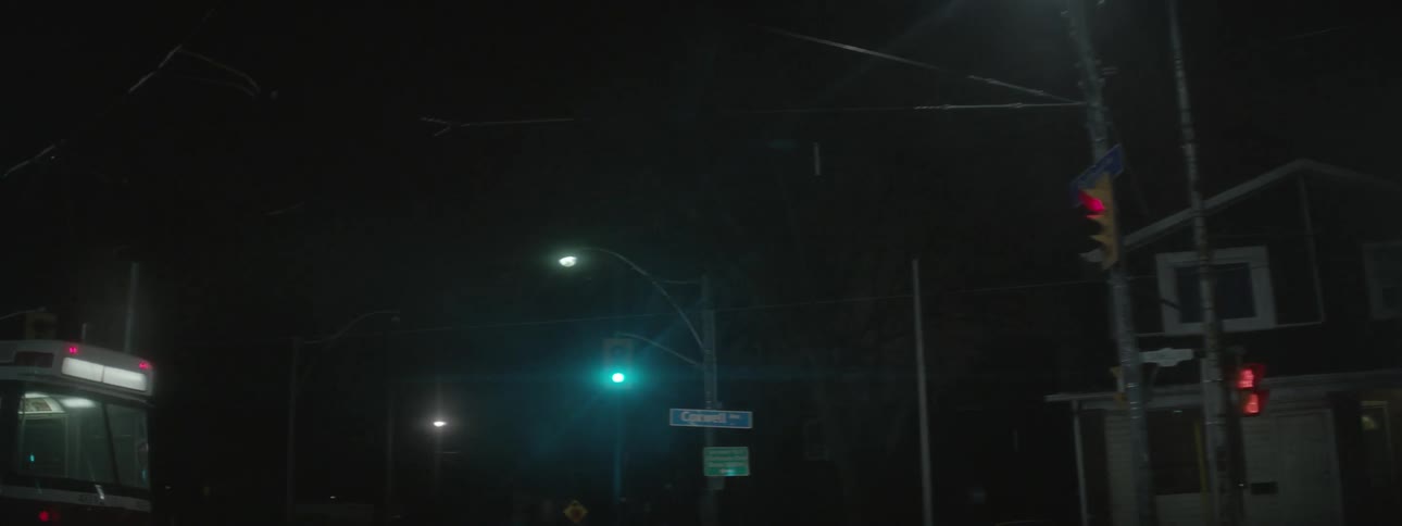 A bus makes a turn on the street at night