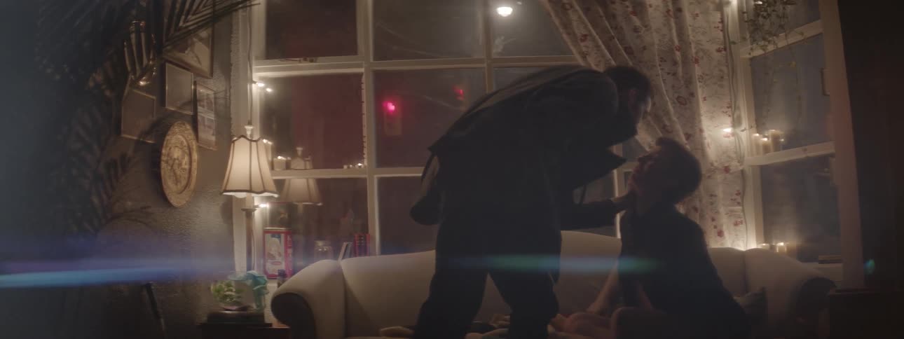 A man gets up and puts his coat on
