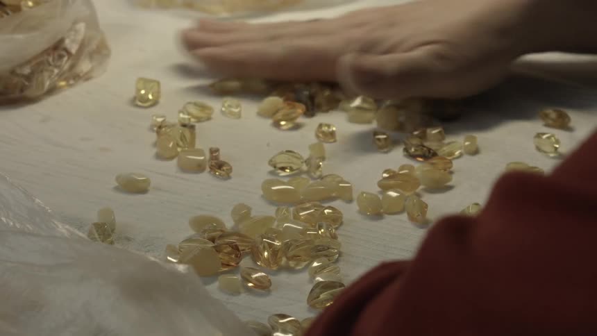 A person spreads out yellow beads