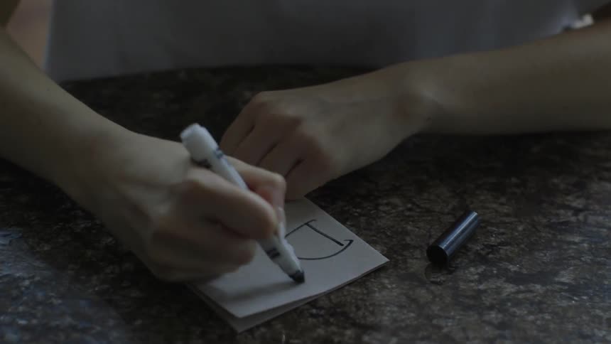 A person writes dad on a card