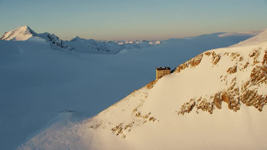 A building on the edge of a snowy mountain