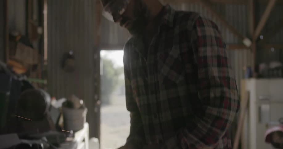 Man grinding a piece of metal in a workshop