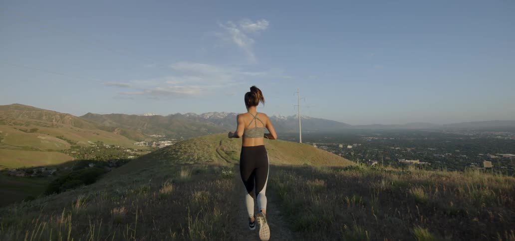 A woman jogs through a field