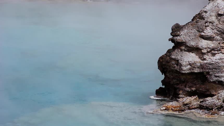 Steam rises from a shallow pool of water