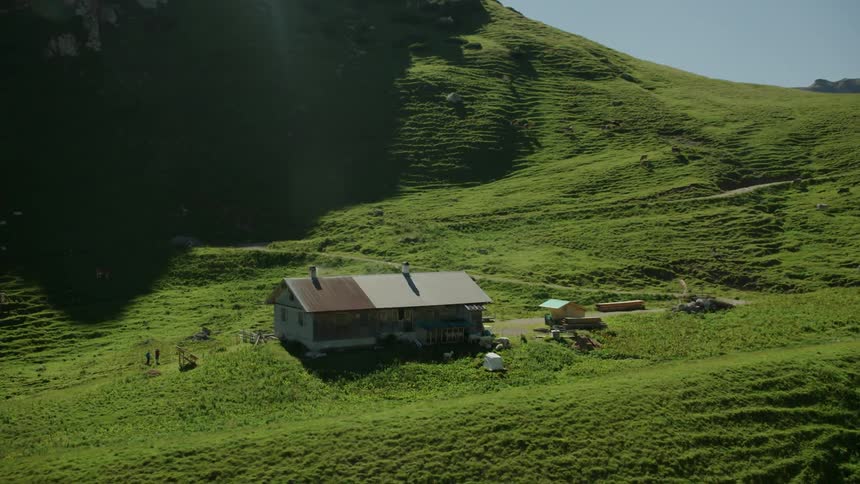 The mountain has a single home on the green top