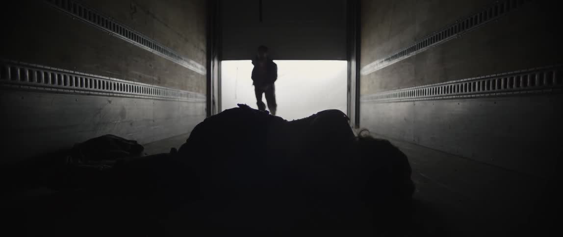 A man opens a trailer then goes inside and closes it