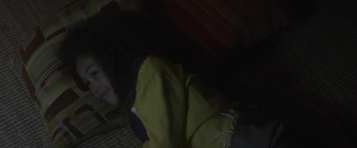 Child lays in bed smiling