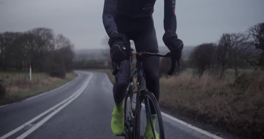 A bicyclist rides on a rural road