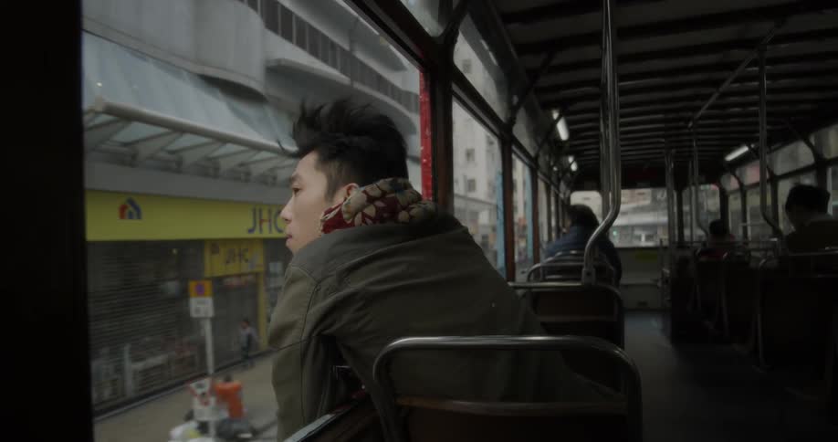 A man leans out the window of the moving bus