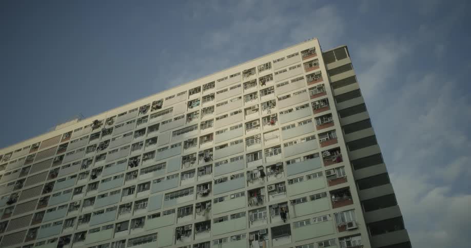 Clouds hover over a large apartment building