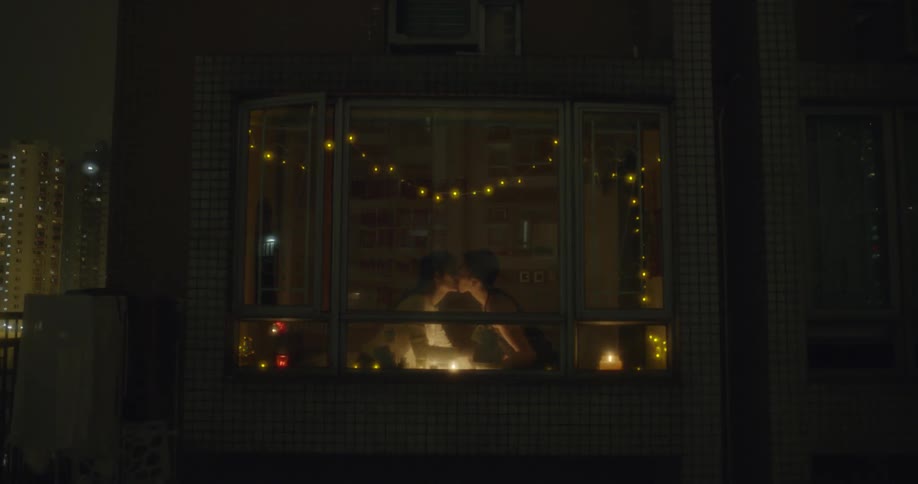 Two people inside the home lean forward and kiss