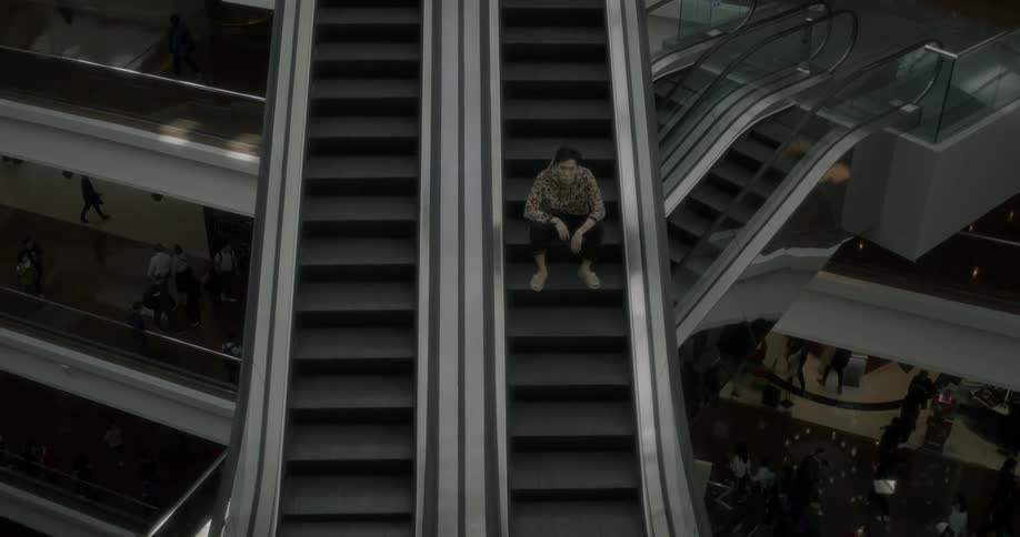 A man sits on an escalator