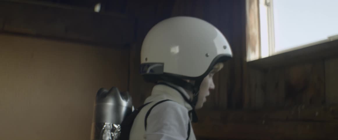 A boy in a space outfit jumps up and around playing