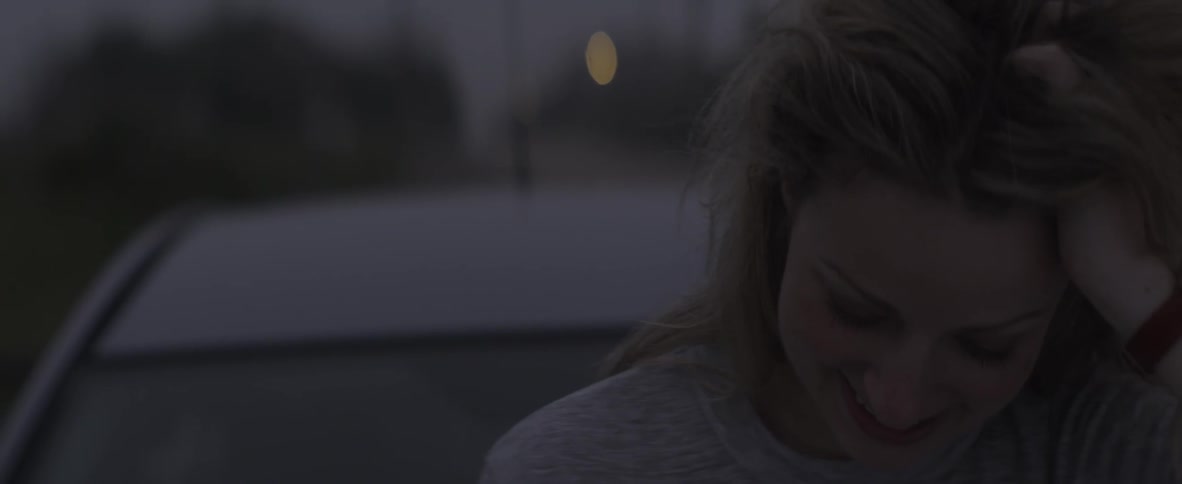 Woman looking at cell phone laughing and shaking her head