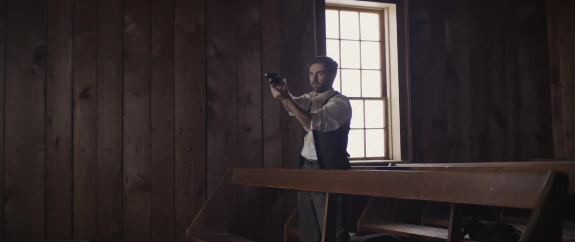 A man is pointing a gun by the window