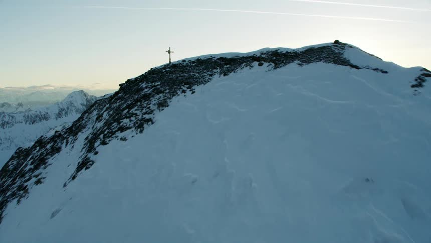 A cross at the top of a snowy mountain