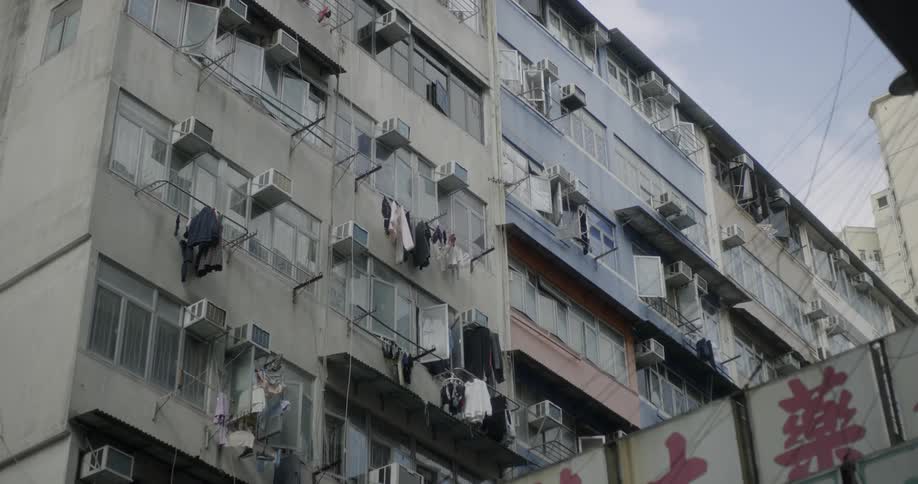 The building has many air conditioning units in the windows