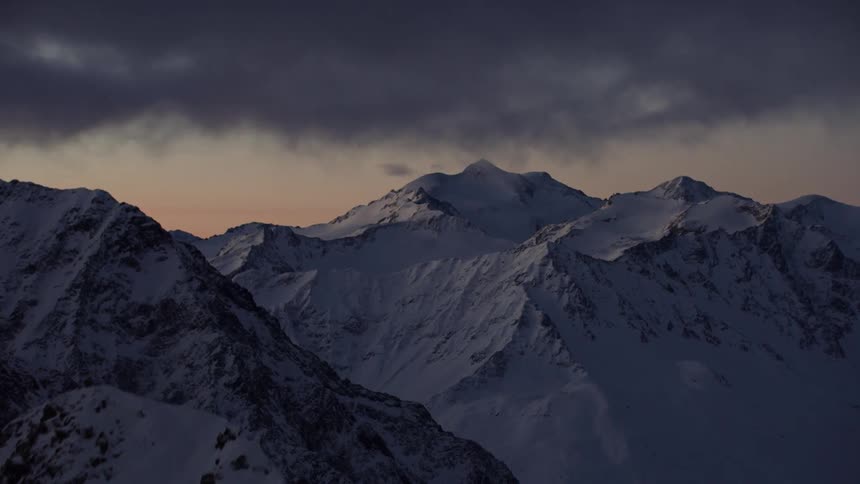 Snow covered mountain peaks at sunset