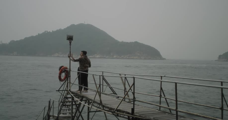A couple are taking photographs by the pier