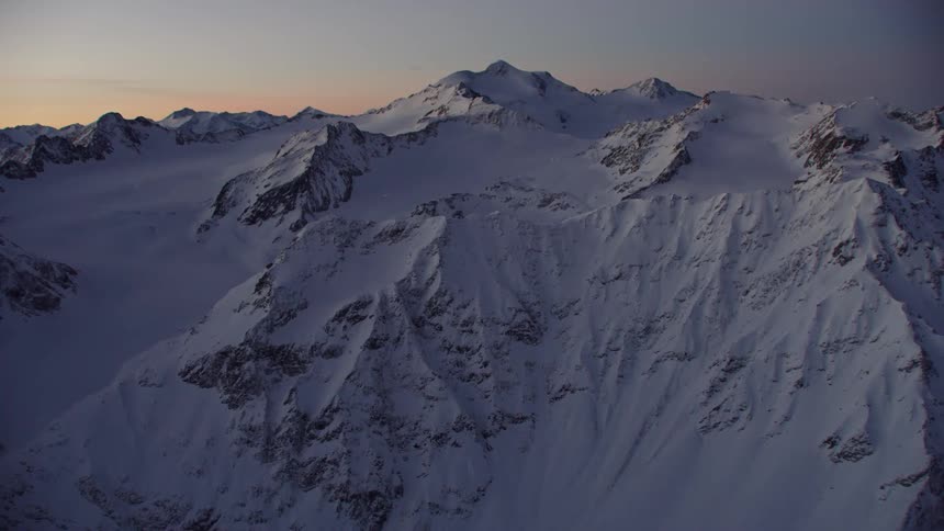 A snow covered mountain at sunset