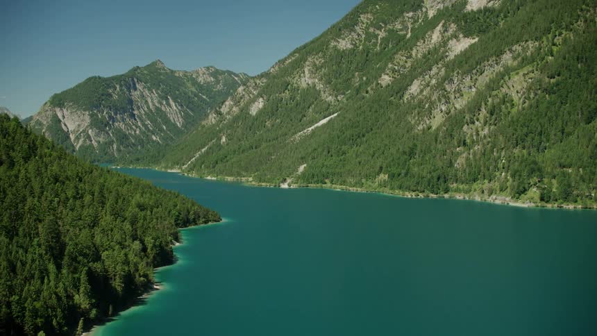 Turquoise blue lake in between mountain forest