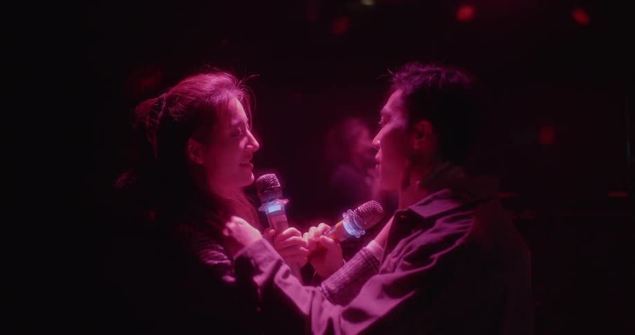 Two people are dancing and singing together