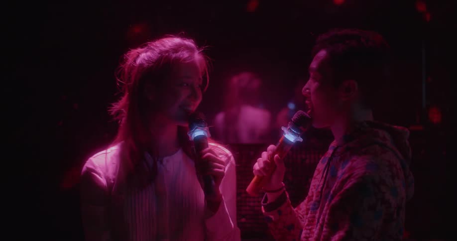 A man and woman sing in a karaoke bar
