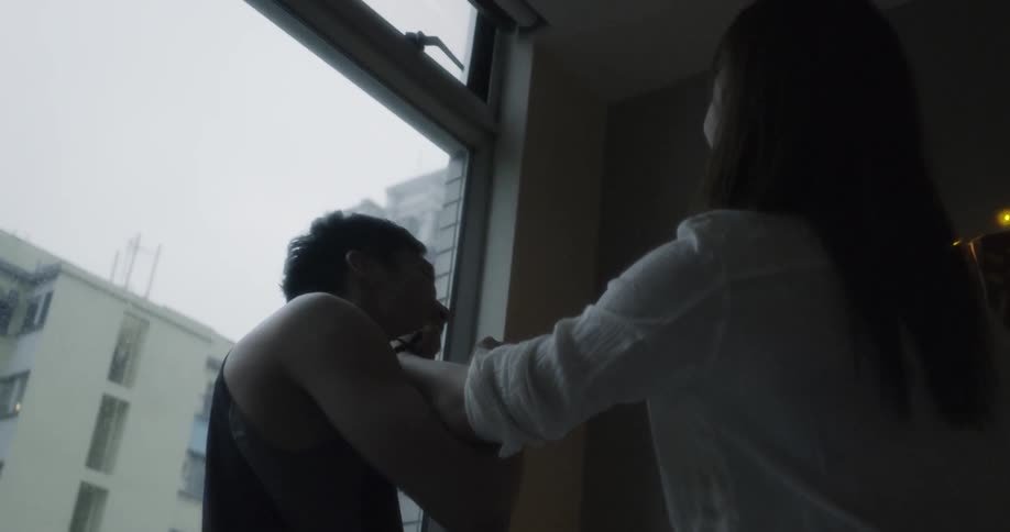 A woman laughs as she grabs a man's face