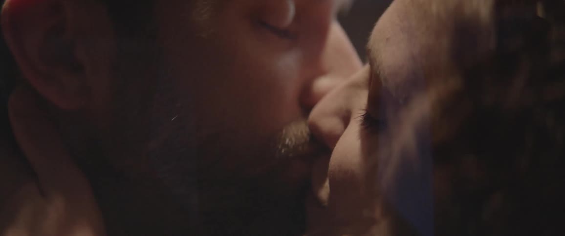 Two people are kissing before turning to the side