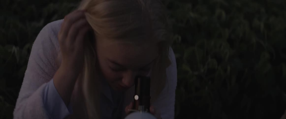 A woman looks through a telescope and calls a child over to look as well