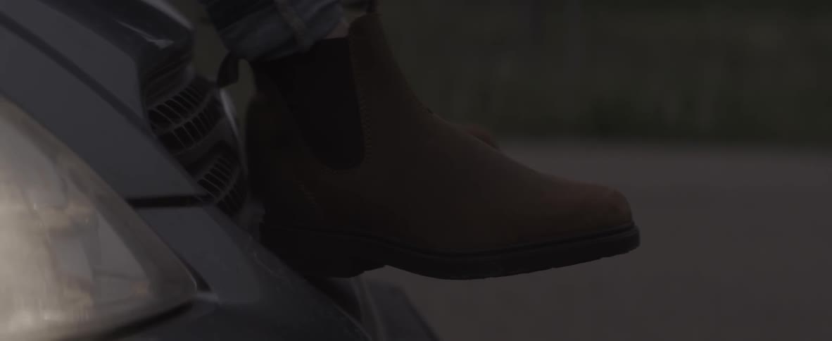 A person is sitting down wearing boots