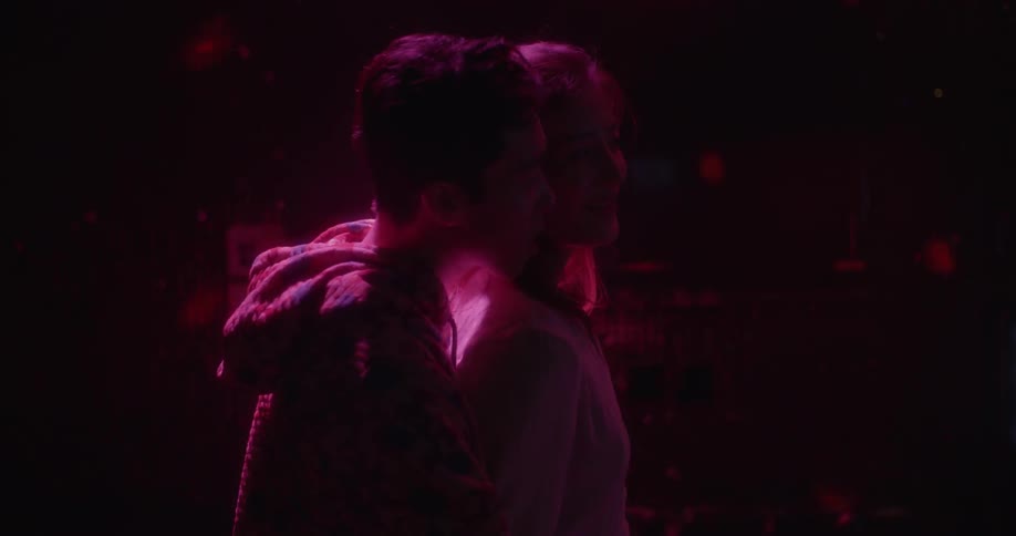 A man and woman flirt and dance together